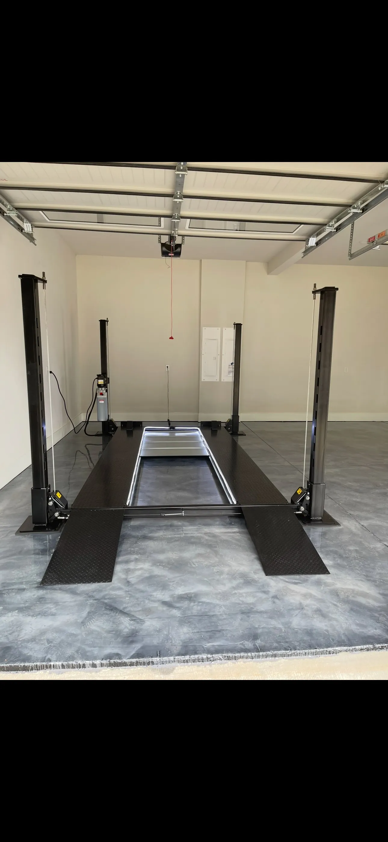 Four-post automotive lift installed in a garage