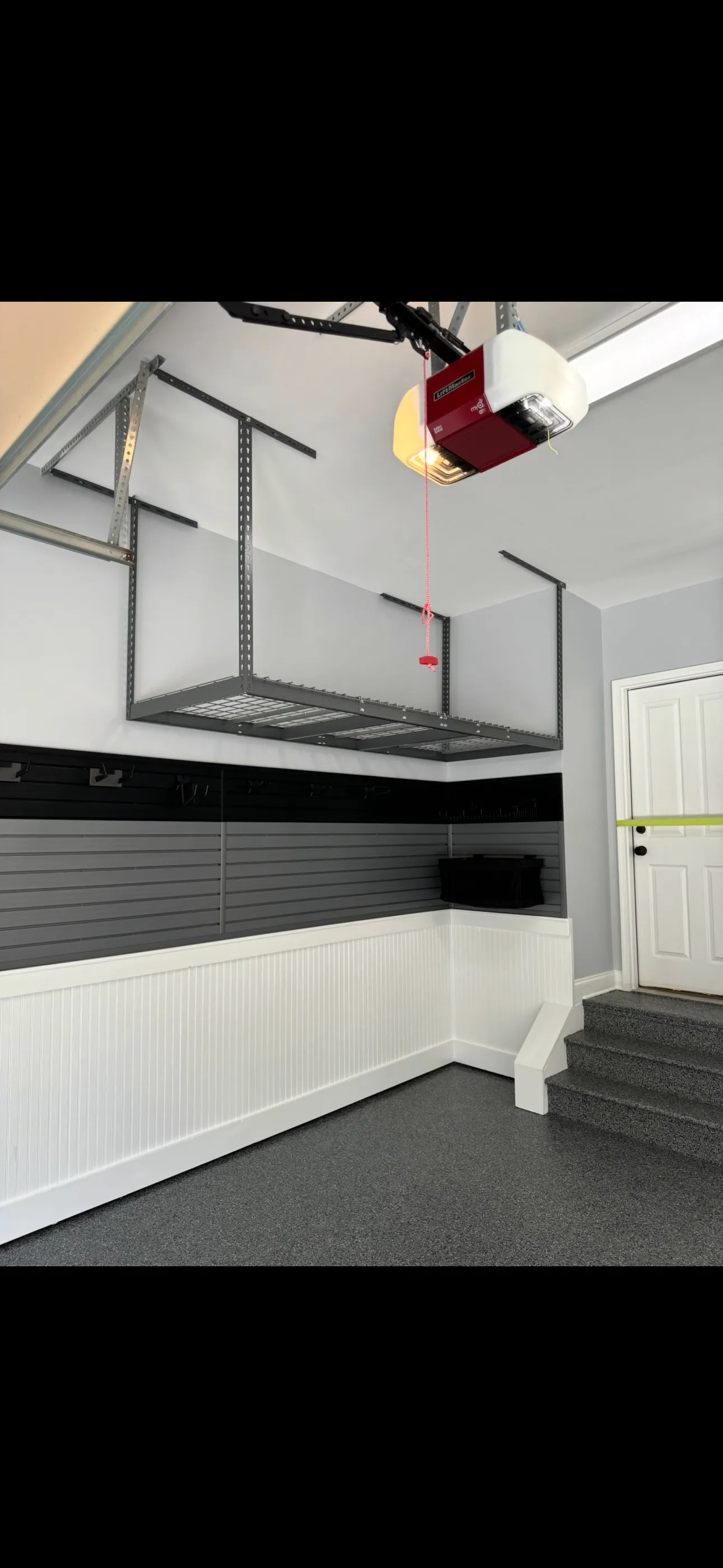 Overhead storage with slatwall and flake floor below.